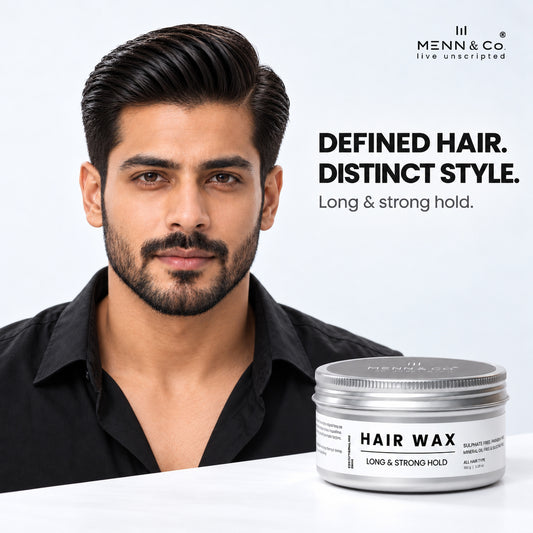 A man with styled, defined black hair wearing a black shirt, shown next to a jar of Henn & Co Hair Wax on a white surface against a light gray background.