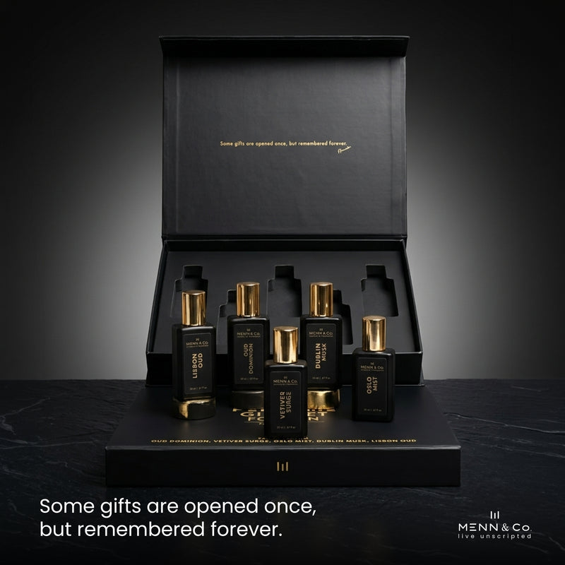 Set of black and gold perfume bottles with a black box on a dark background, featuring Menn & Co branding.