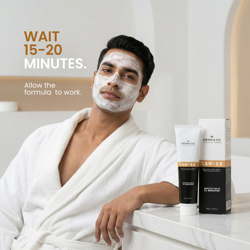 Man applying facial mask with skincare products on a counter