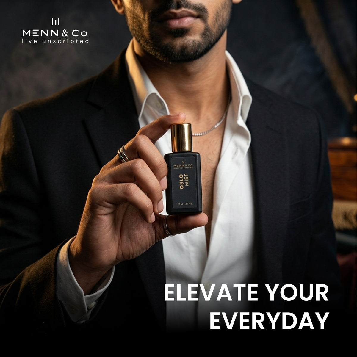 Man holding a Menn & Co perfume bottle with text 'Elevate Your Everyday' on a dark background.