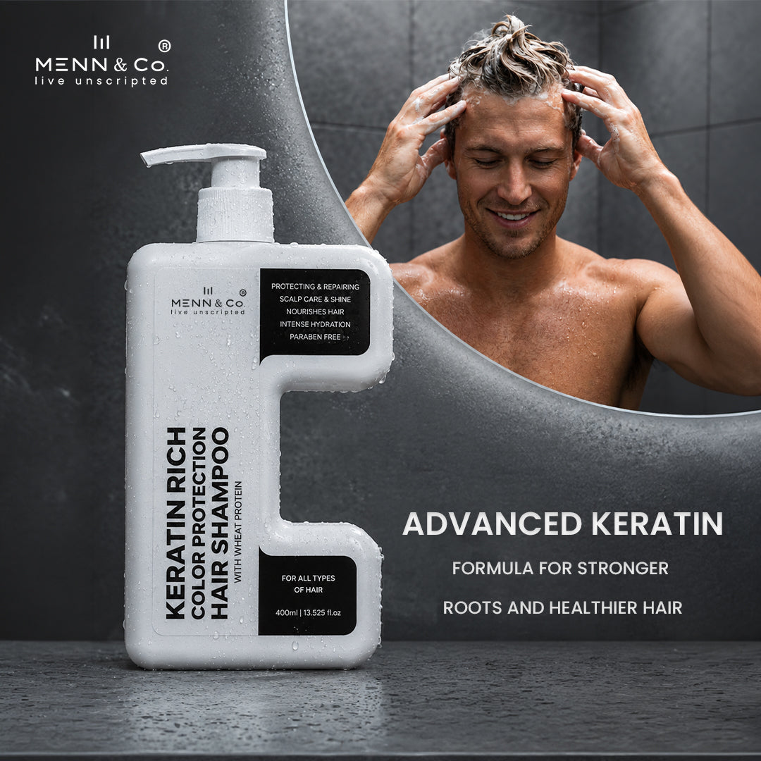 Menn & Co Keratin Rich Color Protection Hair Shampoo bottle shown in front of a shower scene with a shirtless man washing his hair. The bottle is white with black text and black label blocks, and the background is a dark gray bathroom/shower setting.