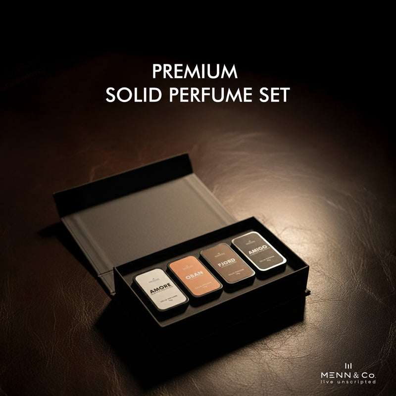 Premium solid perfume set with four different colored containers in an open black box on a dark background.
