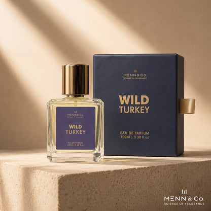 A perfume bottle with a gold cap and purple label stands beside its dark navy box on a stone pedestal. The packaging and bottle are labeled 'Menn & Co.