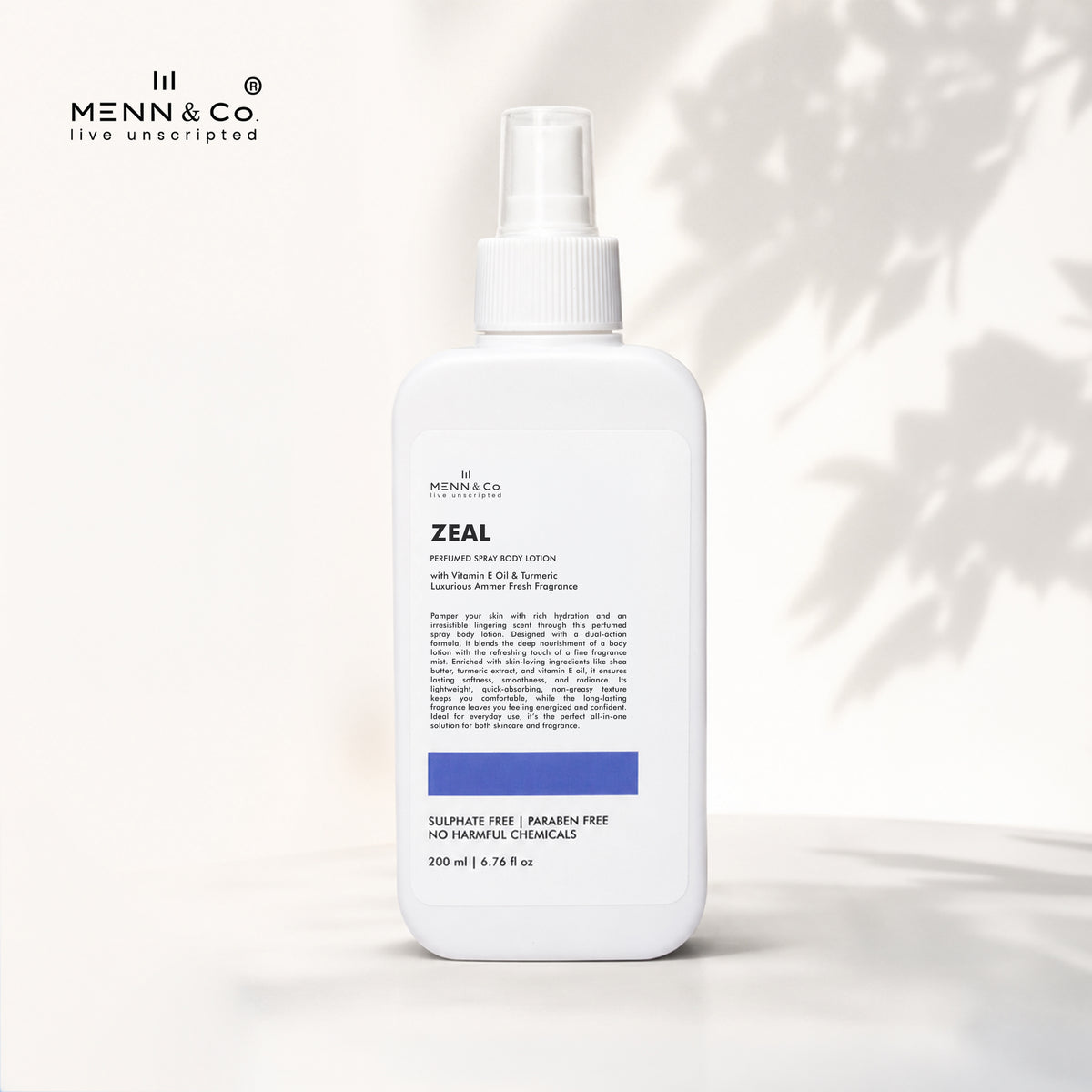 A white bottle of Menn & Co Zeal Handmade Body Lotion with a spray top, set against a warm off-white background with soft leaf shadows. The brand logo 'Menn & Co' is visible in the top left corner.