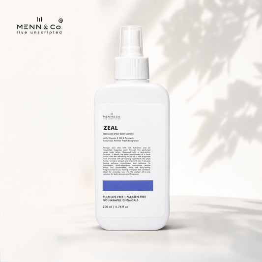 A white bottle of Menn & Co Zeal Handmade Body Lotion with a spray top, set against a warm off-white background with soft leaf shadows. The brand logo 'Menn & Co' is visible in the top left corner.