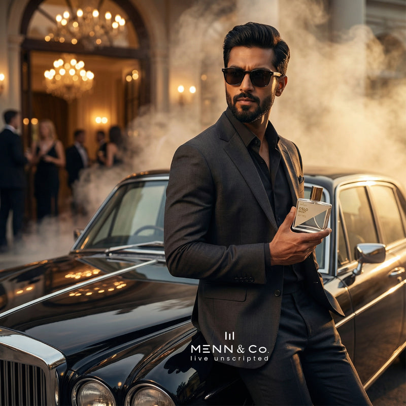 Man in a suit and sunglasses carrying Menn & Co Oslo Mist Perfume standing next to a vintage car with 'Menn & Co' branding.