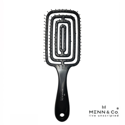 A black paddle hairbrush with a unique rectangular, concentric-oval bristle design, shown on a solid white background with the Menn & Co logo in the bottom right corner.