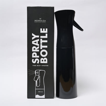 A black spray bottle with a trigger nozzle stands next to its black retail box. The box features white text reading 'SPRAY BOTTLE' and 'FINE MIST SPRAYER' with the brand 'Menn & Co Professional' visible at the top.