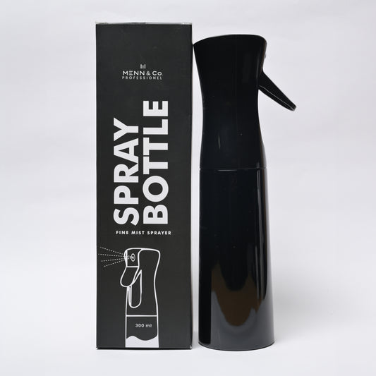 A black spray bottle with a trigger nozzle stands next to its black retail box. The box features white text reading 'SPRAY BOTTLE' and 'FINE MIST SPRAYER' with the brand 'Menn & Co Professional' visible at the top.
