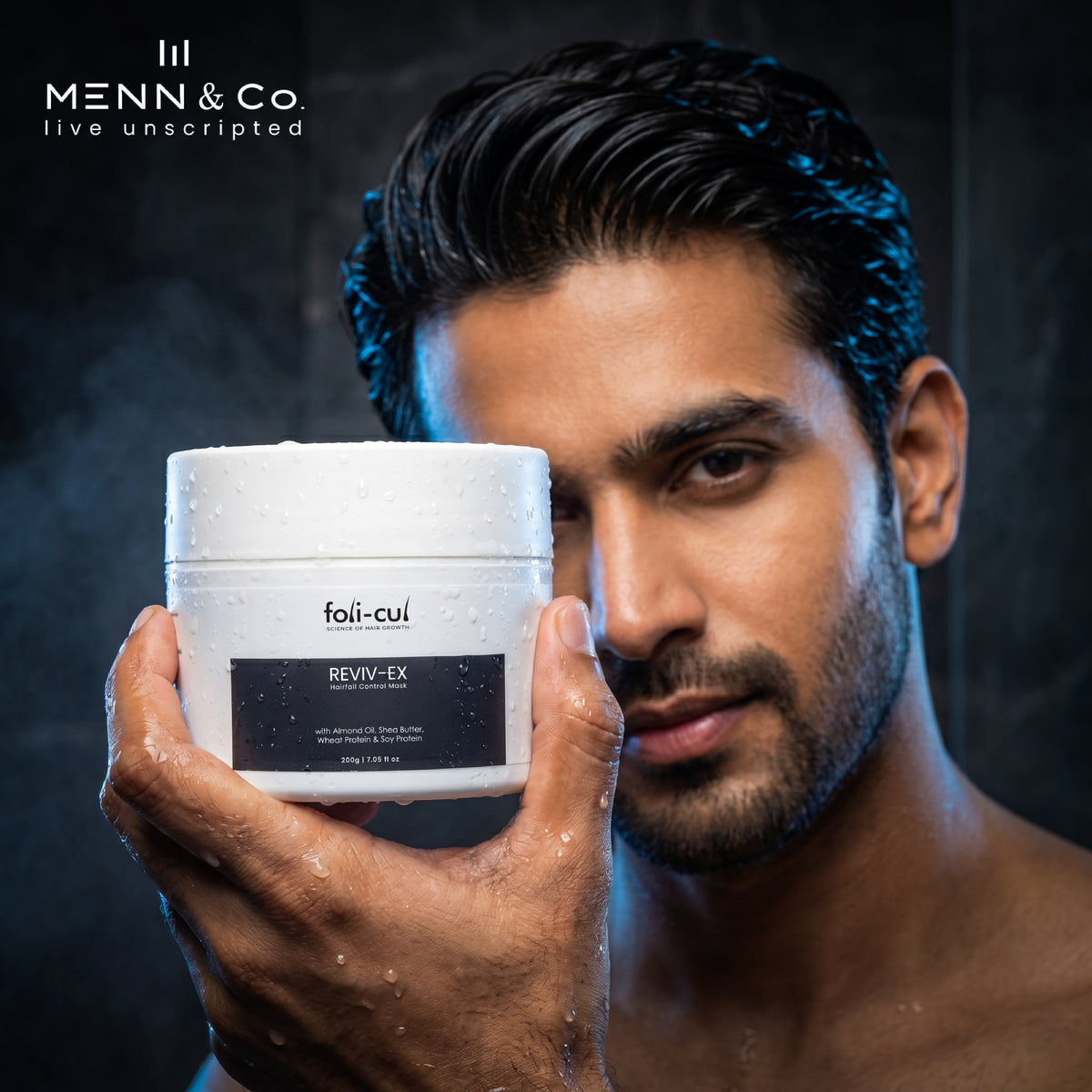 Man holding a container of  Foli-Cul hair fall control Mask product with a dark background