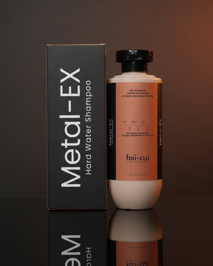 Metal-EX hard water shampoo bottle and packaging on a reflective surface with a dark background