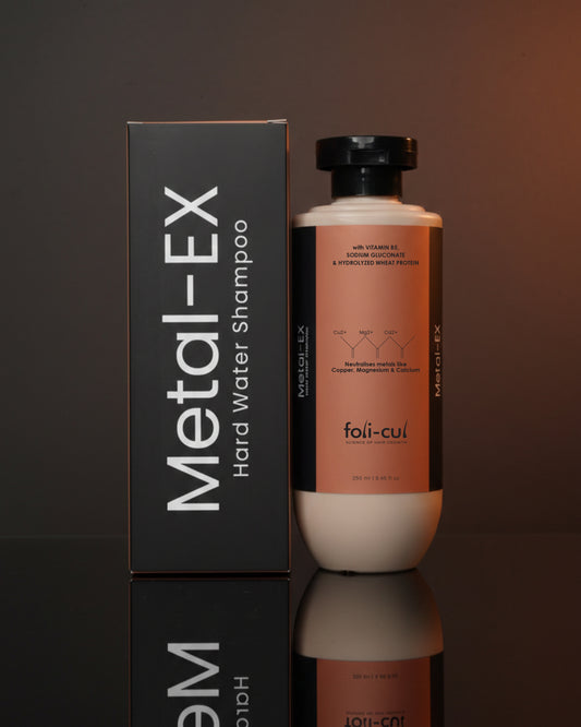 Metal-EX hard water shampoo bottle and packaging on a reflective surface with a dark background