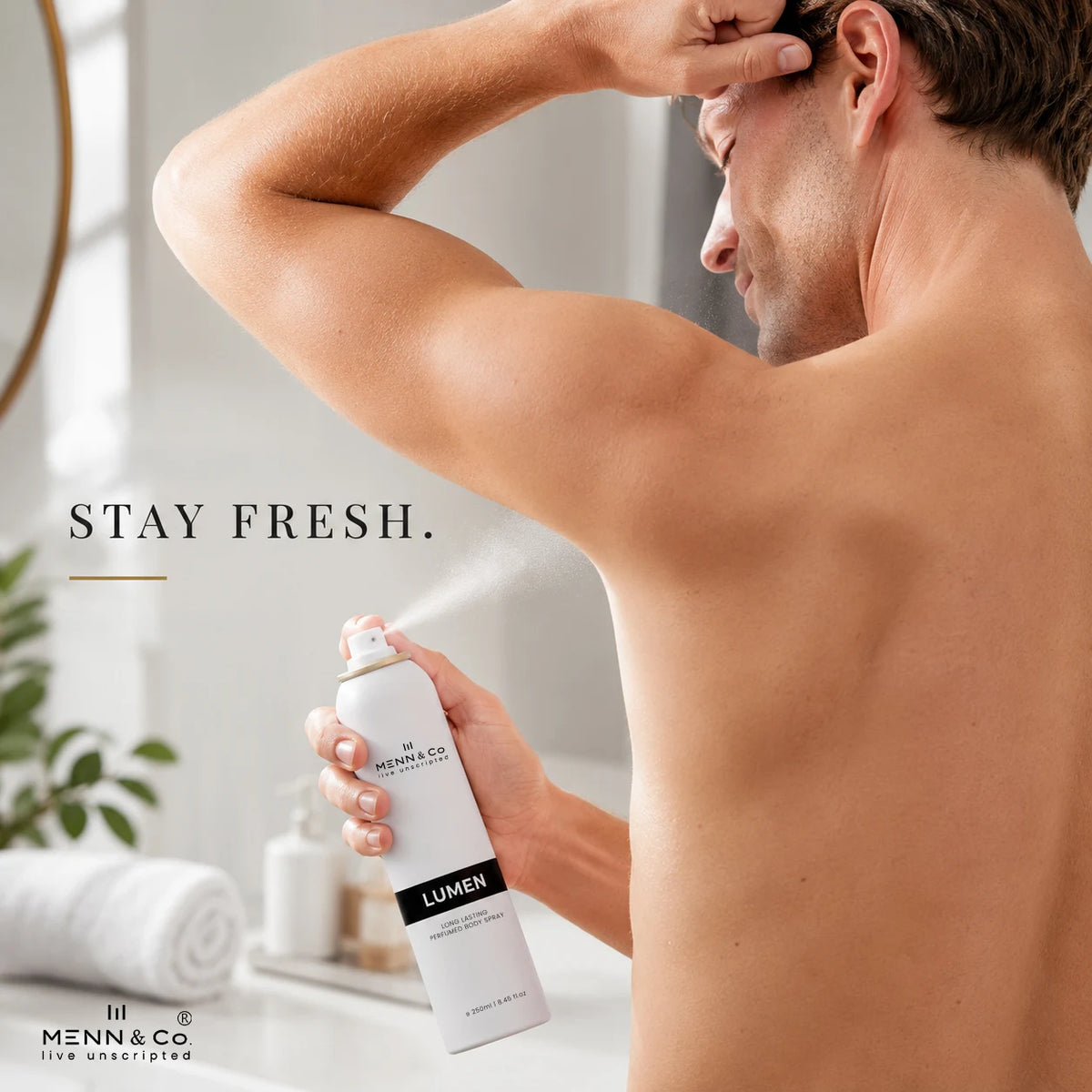 Man applying deodorant with 'MENN & CO' and 'LUMEN' branding in a bathroom setting.